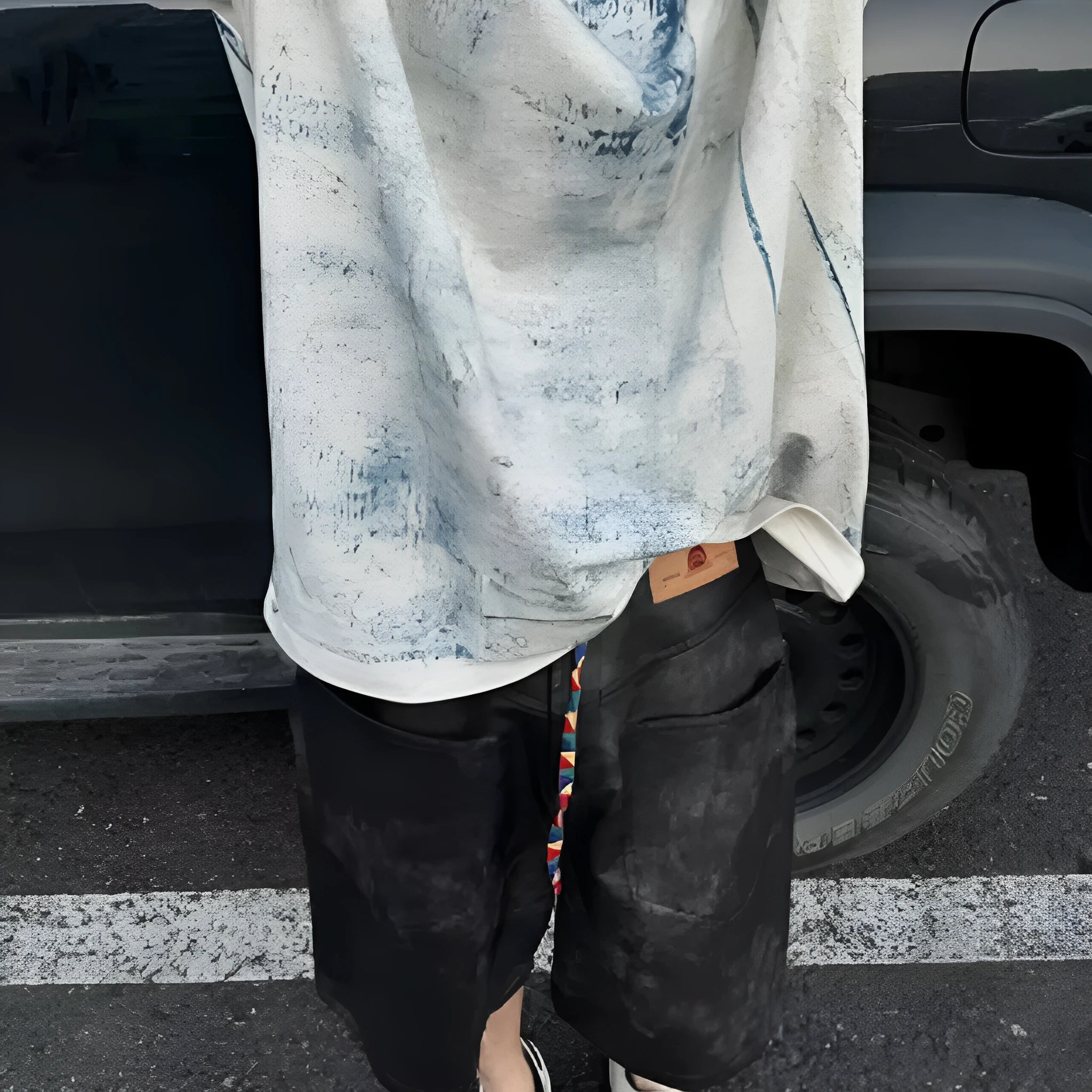 Men's loose-fit short-sleeve T-shirt with distressed print and tie-dye pattern on grey fabric.