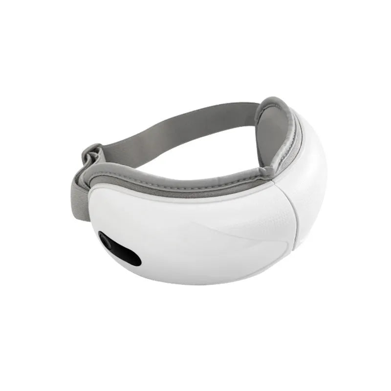 White rechargeable eye massager with hot compress and airbag massage functions on a flat surface
