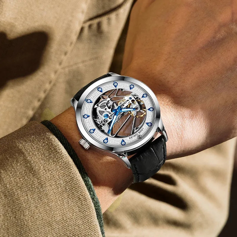 Men's silver mechanical watch with white dial, blue hands, and black leather strap on wrist