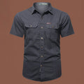 Men's army green short sleeve cotton work shirt with a loose cardigan fit on a hanger.