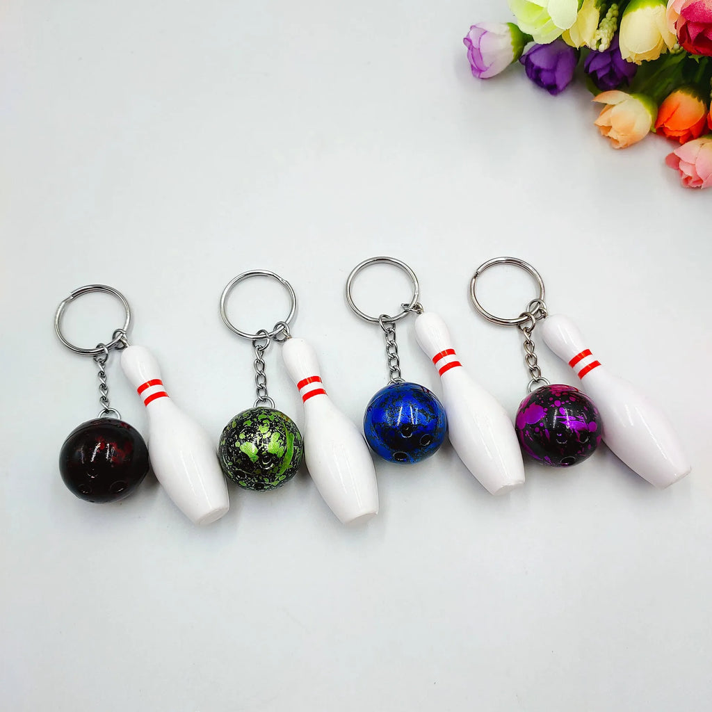 Mini bowling ball keychain in four colour options: dark red, blue, purple, green