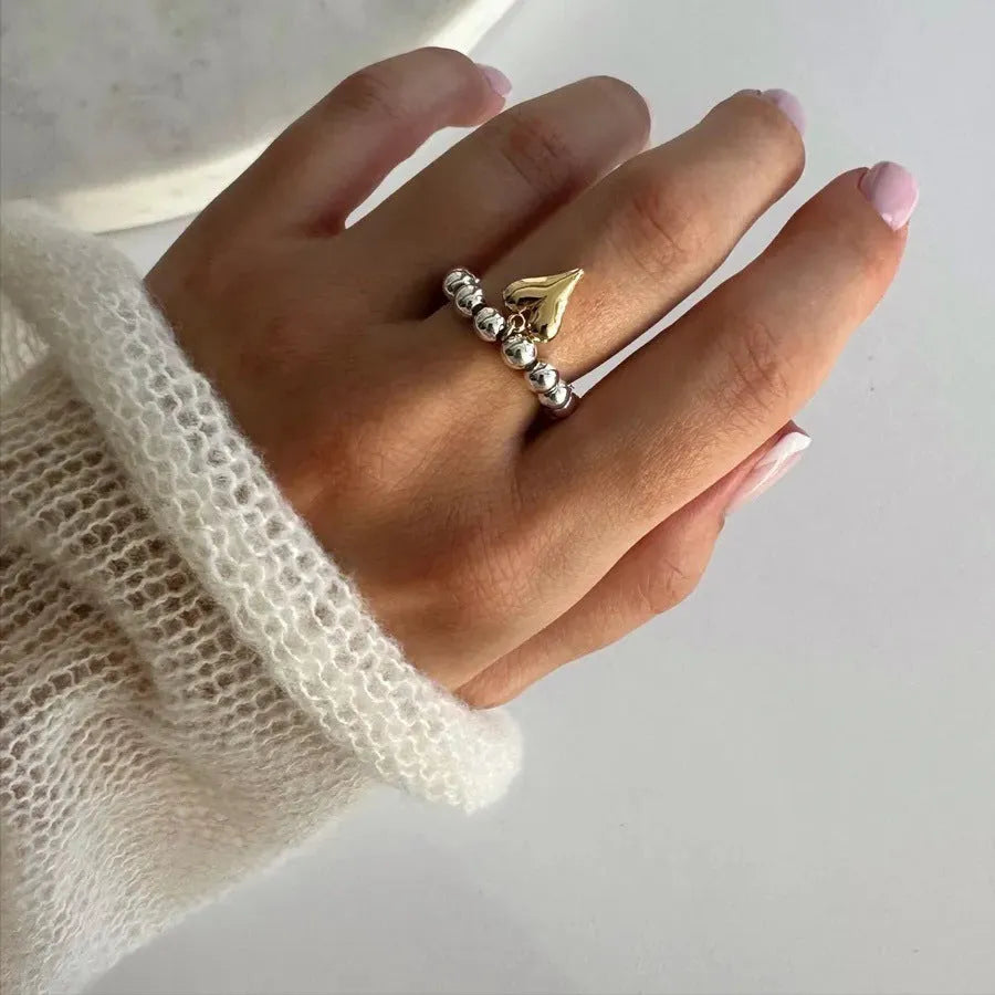 Handmade gold and white elastic beaded ring with a geometric love heart design.