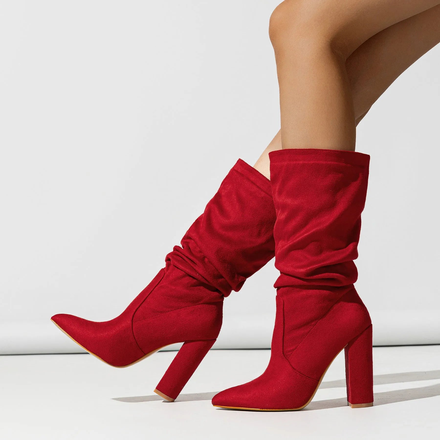 Women's black suede high heel boots with a chunky heel and pointed toe, mid-calf length.