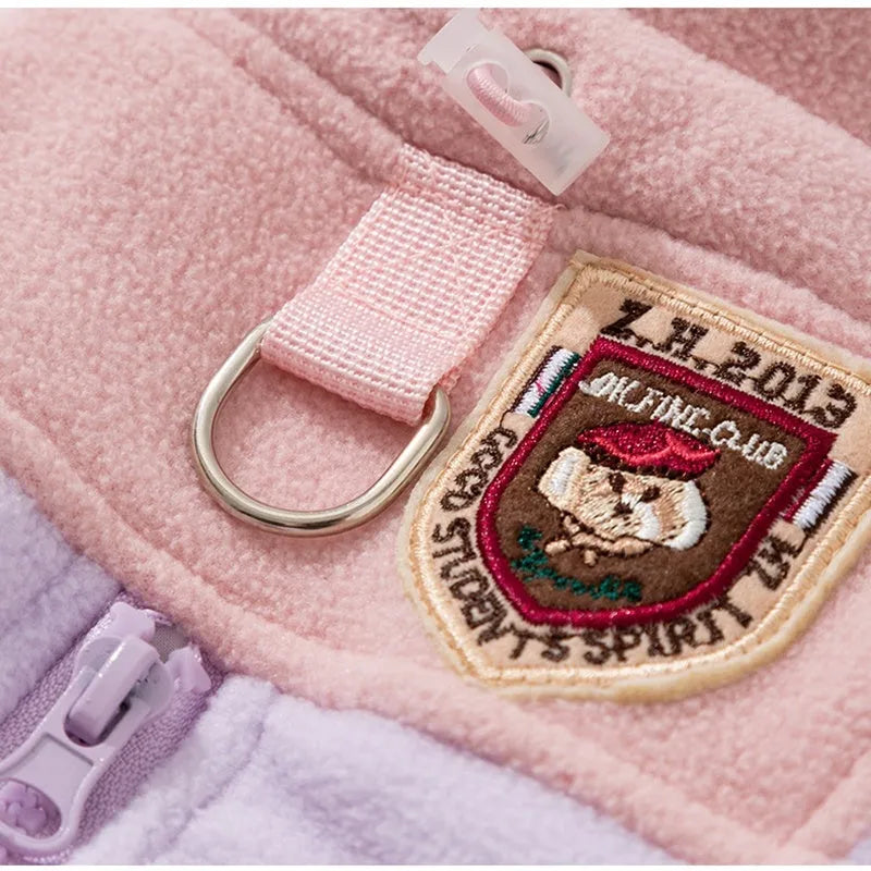 Four-legged fleece jacket for cats and small dogs in colour block design with badge patch, showing front zipper and elastic cuffs.
