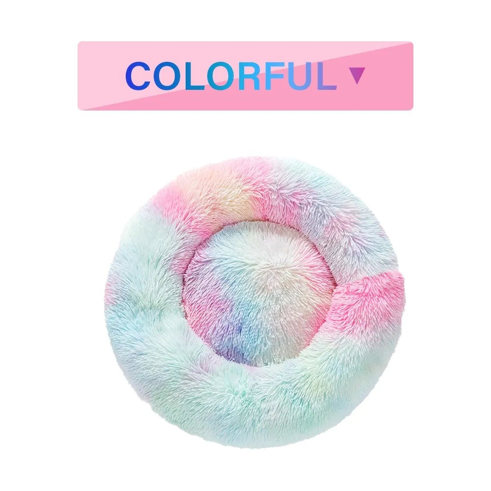 Fluffy donut-shaped pet bed in long plush fabric, shown in a light grey colour with a raised edge.