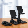 Cool black desktop phone stand with integrated wireless charging pad on an electroplated metal rod.