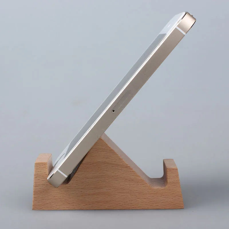 Solid beech wood phone stand with a decorative resin puppy figurine, holding a mobile phone at an angle with a charging cable threaded through the back.