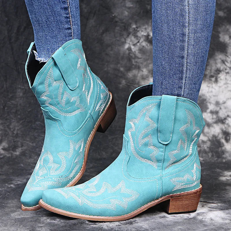 Women's blue embroidered cowboy boots with a wedge heel and pointed toe on a white background.