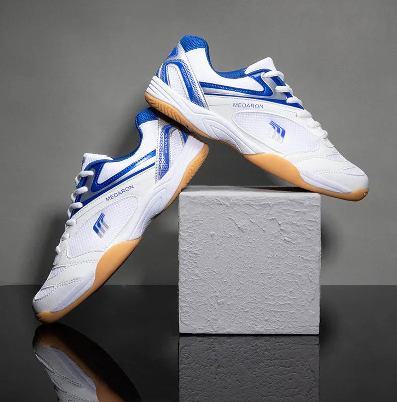 Table tennis sneakers in white and red colour with mesh upper, natural rubber outsole and front lace-up closure