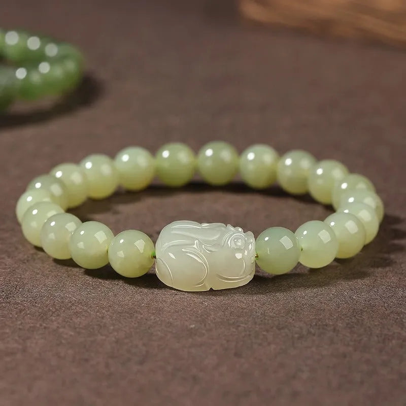 Grey Hetian jade ethnic style bracelet with polished beads on a wrist.