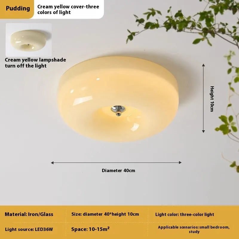 Creamy yellow and white opal shade ceiling light with remote control on a bedroom ceiling.