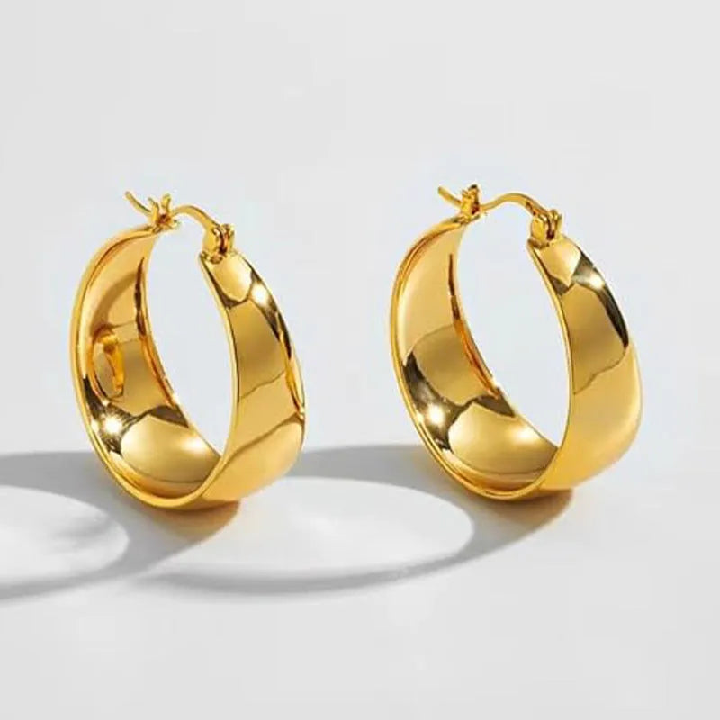 Widened curved stainless steel earrings with titanium construction in gold or steel colour, 25mm or 30mm diameter