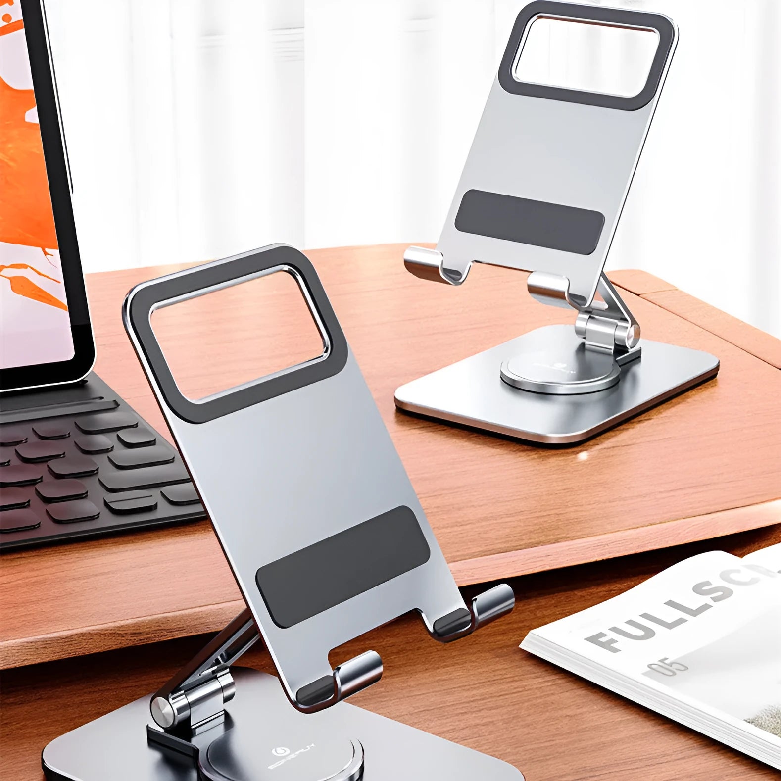 Rotary folding aluminium alloy desktop mobile phone stand in silver on a wooden table