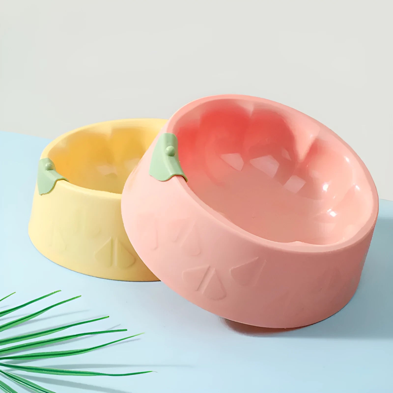 Green plastic double pet bowl with flower-shaped design and anti-tip base for cats and small dogs.