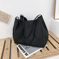Women's solid colour canvas handbag showing horizontal square shape and double shoulder straps