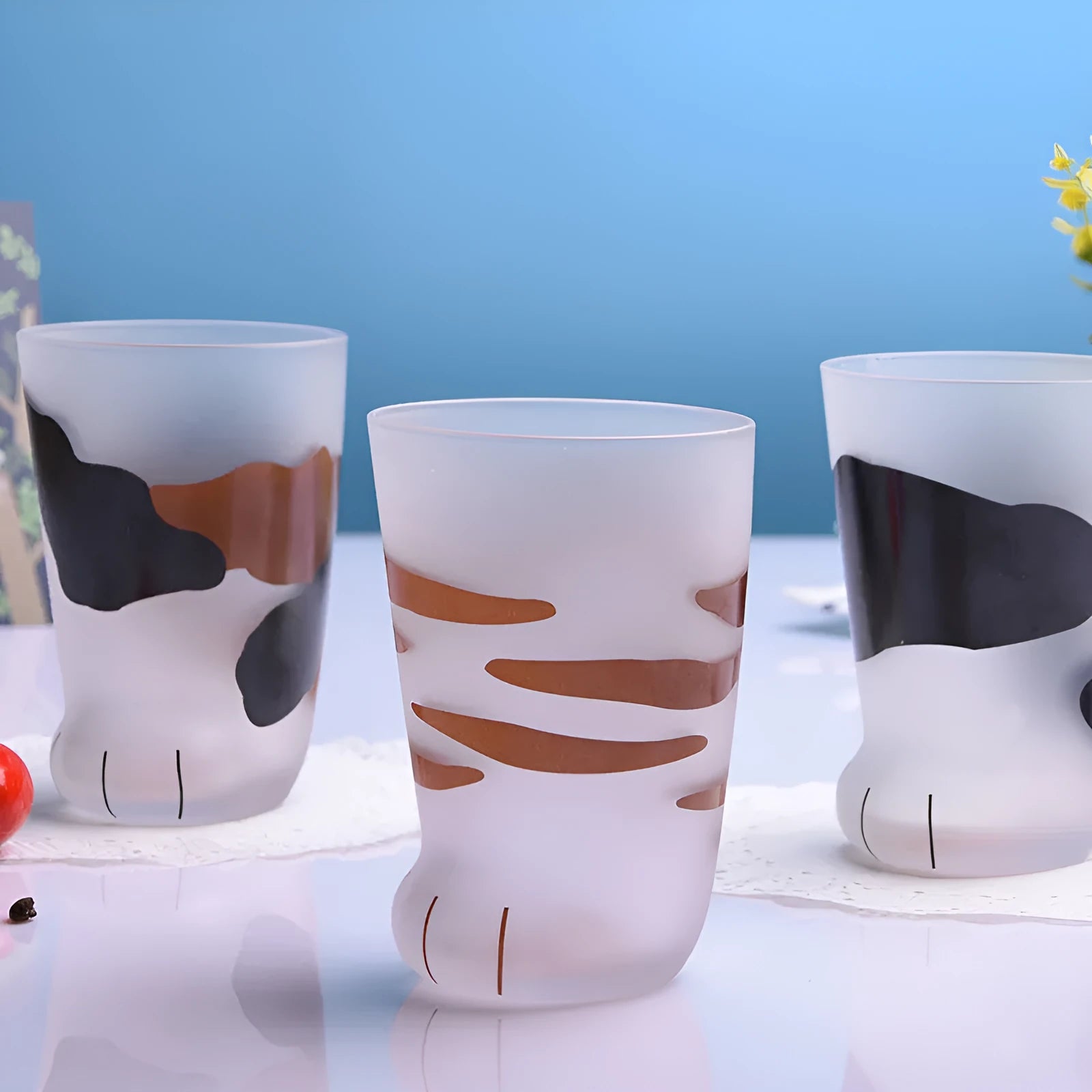 Creative cat paw shaped glass mug with 300ml capacity and frosted texture on a desk