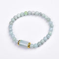 Close-up of a natural emerald green Myanmar jade stone bracelet with round lucky beads on a wrist.