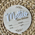 Square wooden newborn name plaque showing baby birth information and surname.