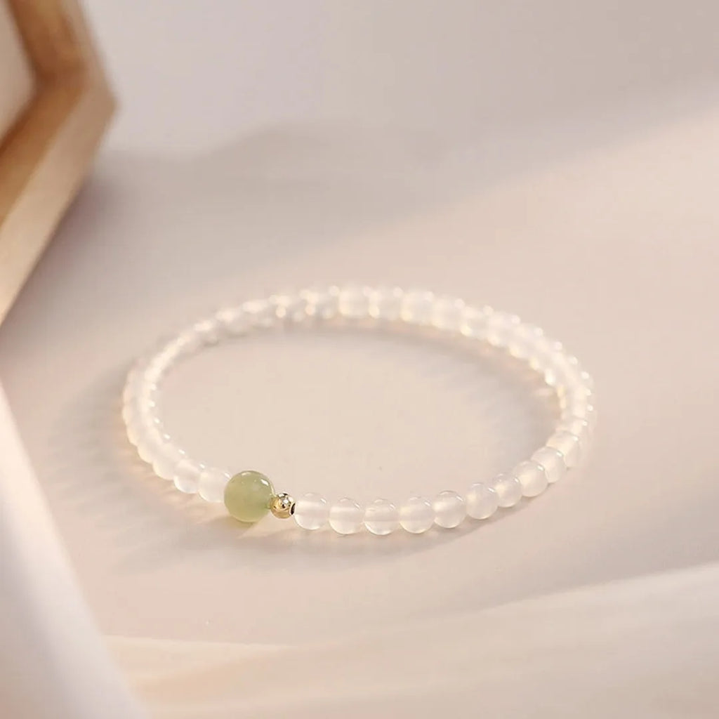 Close-up of a women's bracelet with white agate and Hetian jade beads on a 15 cm strand.