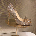 Gold women's pointed toe high heels with rhinestone and sequin decoration on a stiletto heel.