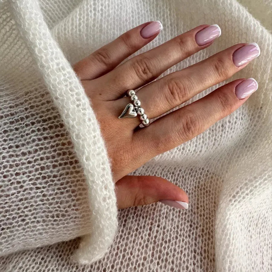 Handmade gold and white elastic beaded ring with a geometric love heart design.