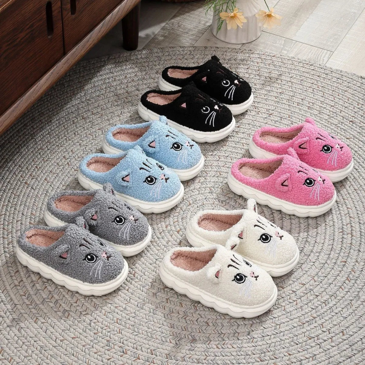Pair of pink winter cartoon cat fluffy slippers on floor, non-slip EVA sole
