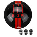 Close-up of a clear acrylic universal 5-speed manual gear head with black ball and red lettering on a car shift lever