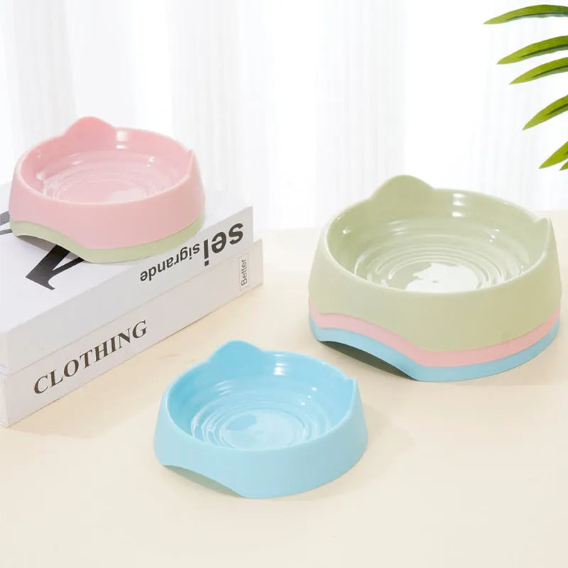 Blue ceramic dog slow feeder bowl with internal maze design, shown next to a green and pink version.