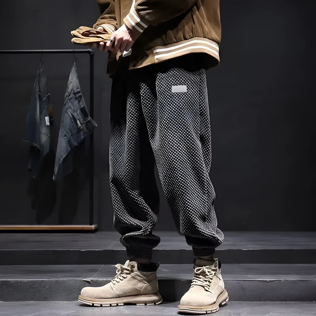 Man wearing grey straight-leg sweatpants with an ankle tie closure.