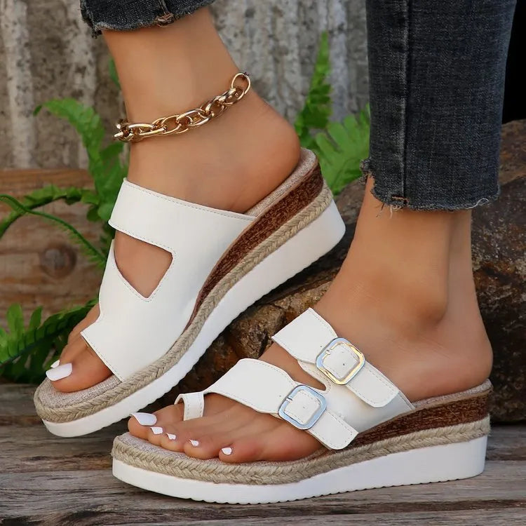 White patent leather women's wedge sandals with peep toe and woven detail on a rubber sole.