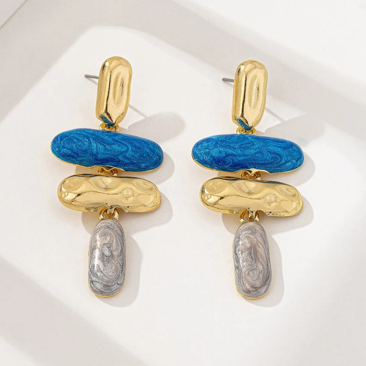 A pair of women's geometric stud earrings with a multicolour electroplated finish on a zinc alloy base.