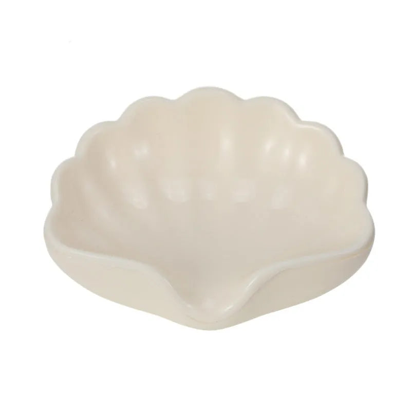 White plastic shell-shaped soap dish on bathroom countertop