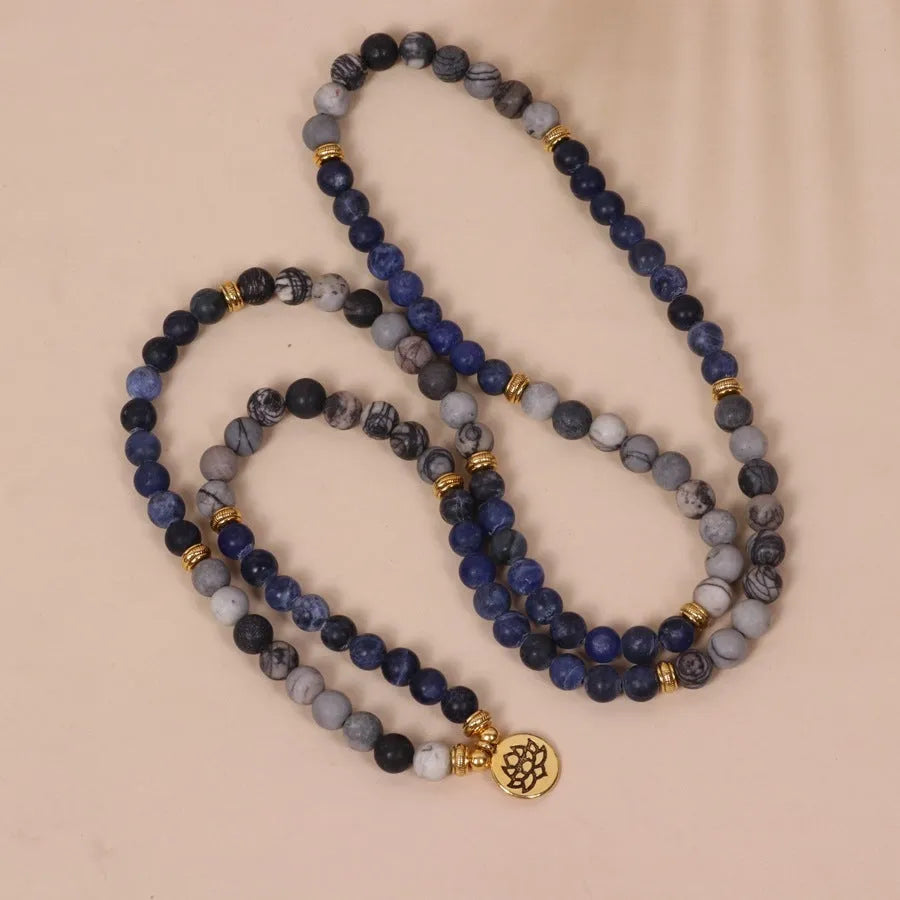 Blue multi-layer bracelet with patterned network stone beads and alloy components.