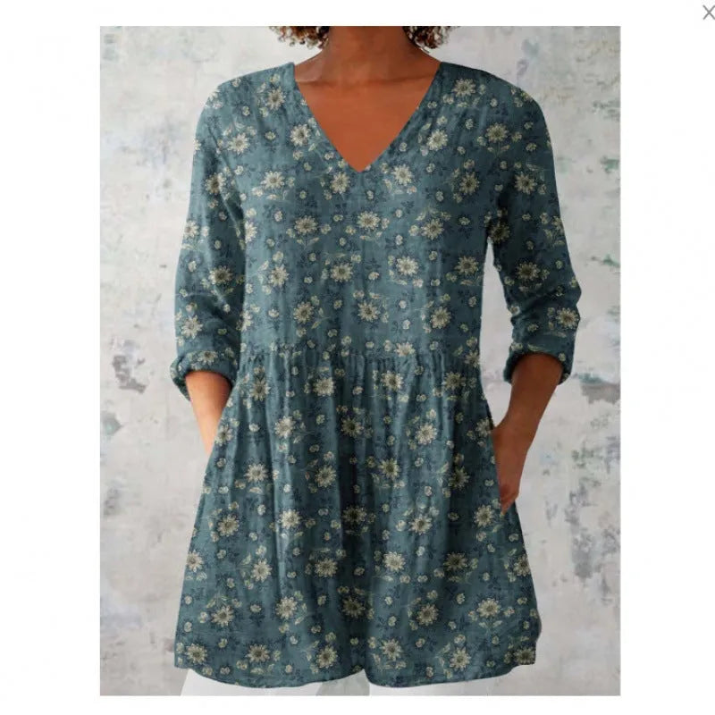 A woman wearing a printed, loose-fitting dress with a wide waist and three-quarter length sleeves.