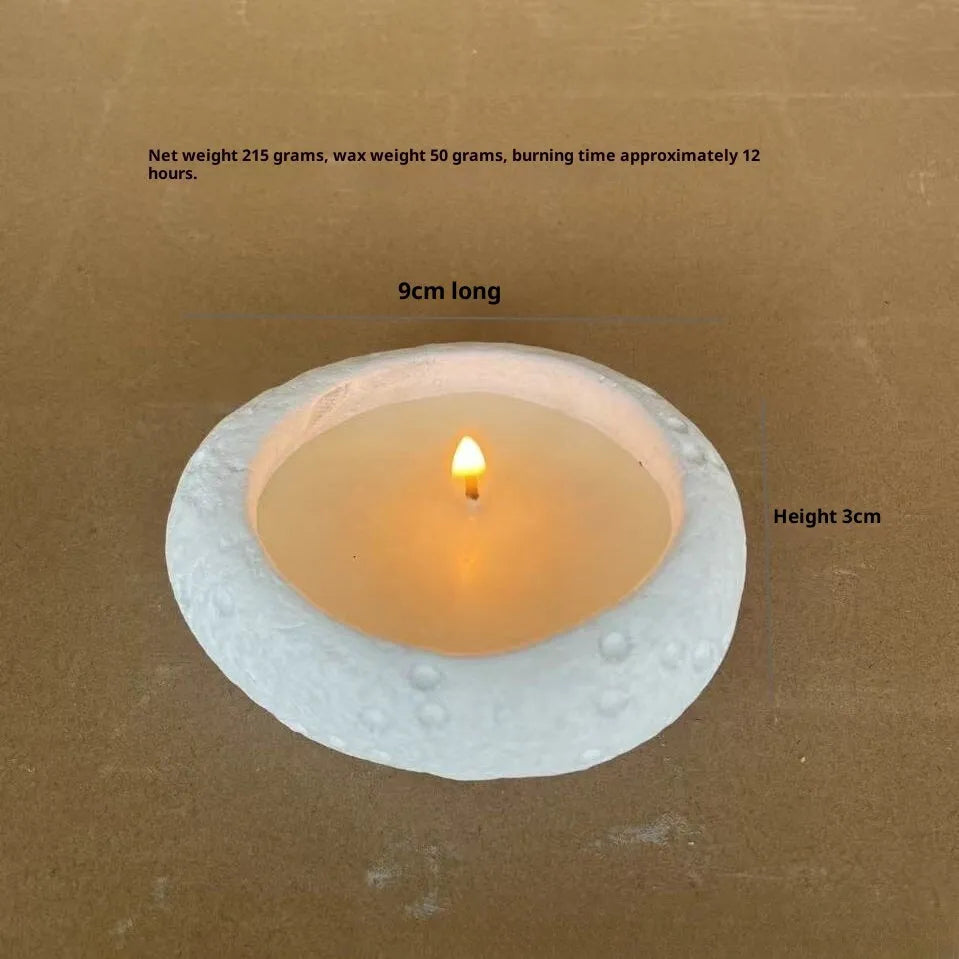 White cement candlestick ornament with fair-faced finish holding a candle