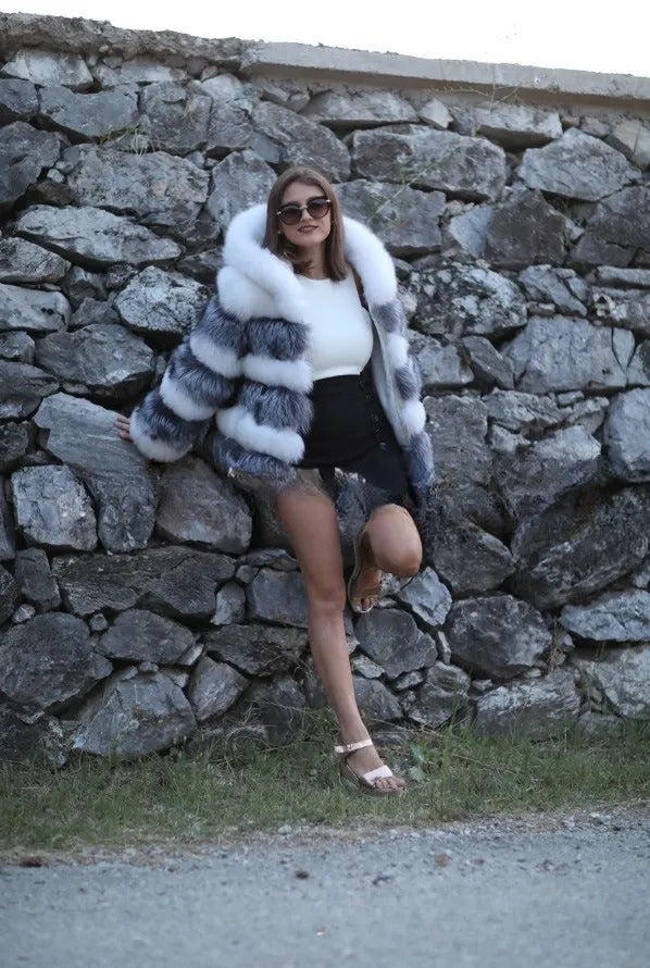 Women's loose fit artificial fur hooded coat in white silver fox colour on a hanger.