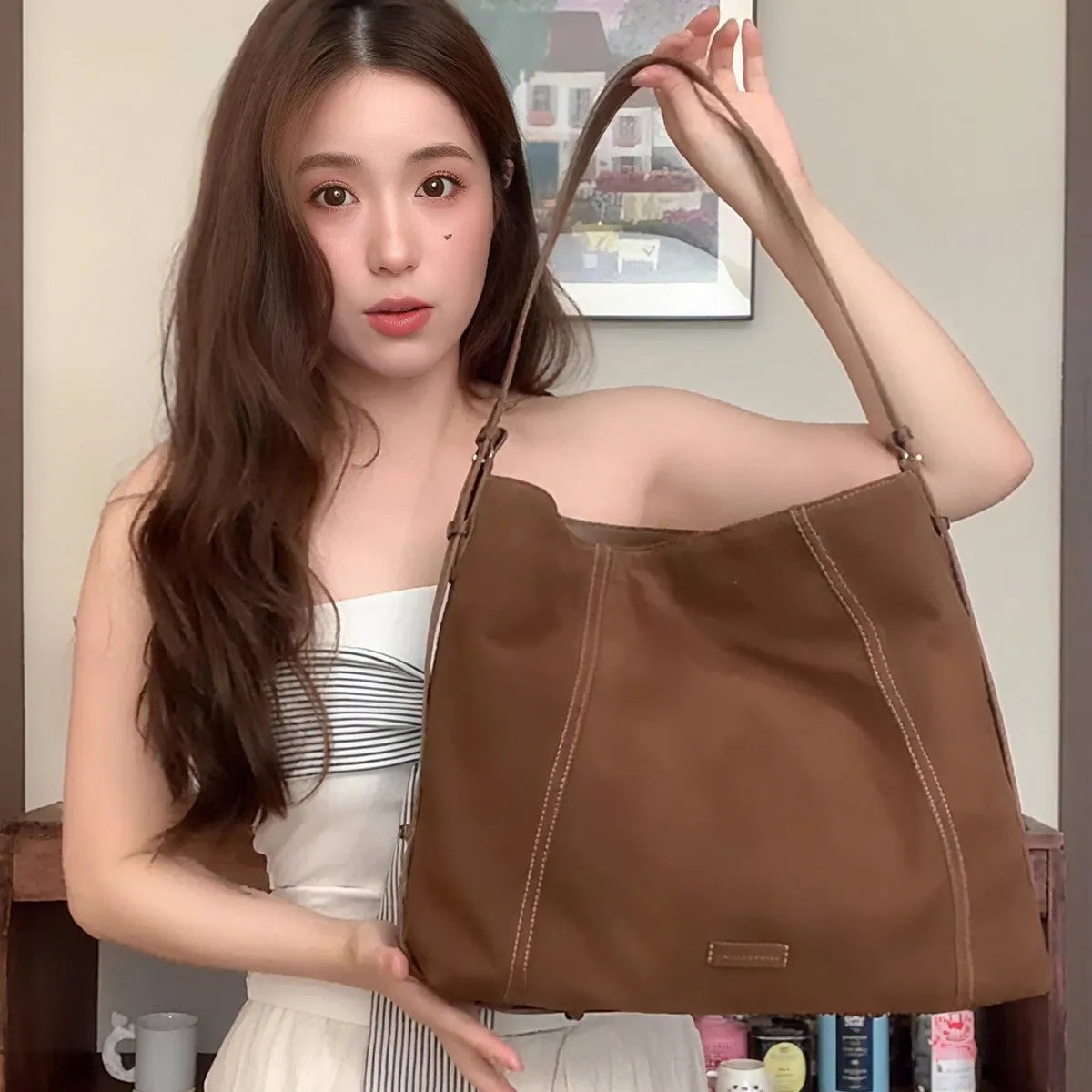 Large capacity coffee colour suede messenger bag with visible sewing line detail and single shoulder strap, shown on a plain background.
