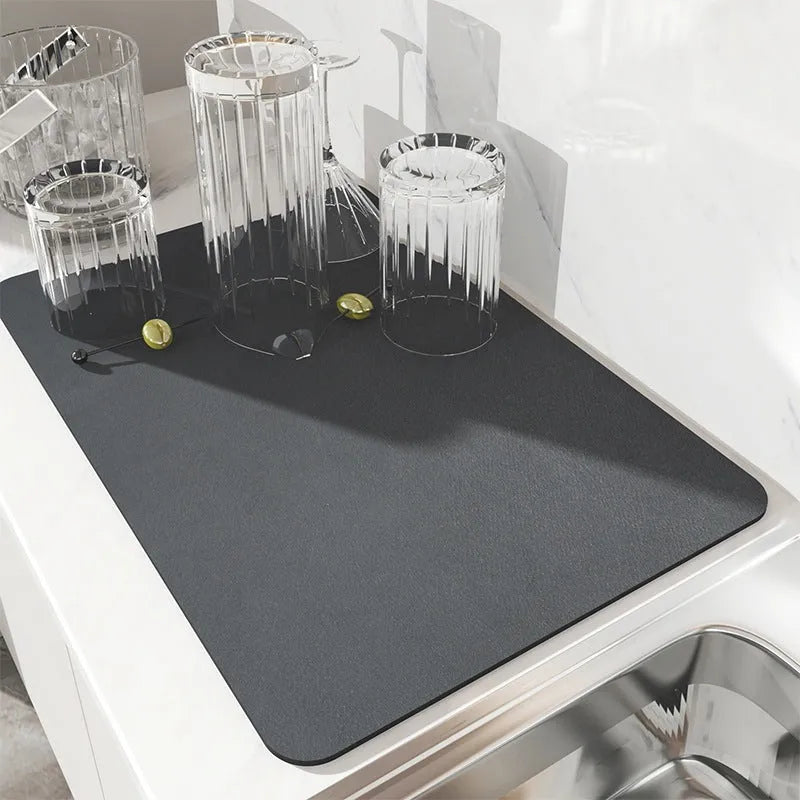 Black super absorbent rubber-backed kitchen drain mat on a countertop