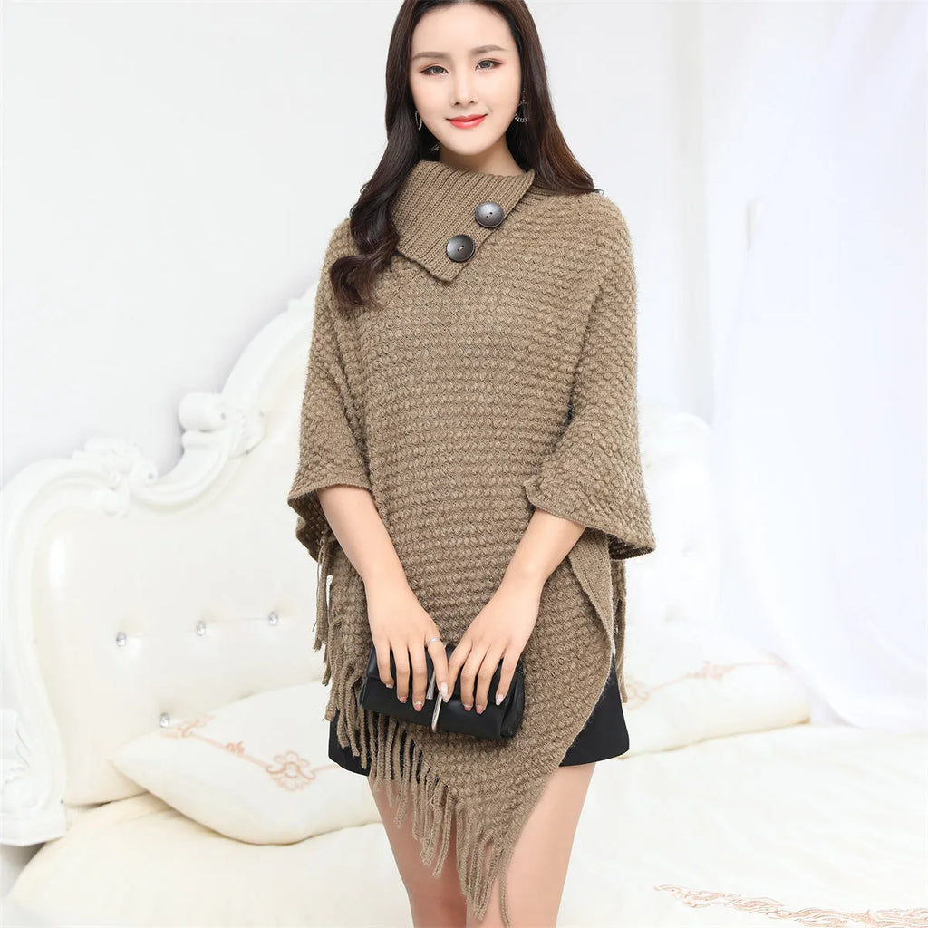 Sleeveless polka dot knit cloak in apricot colour, shown as a vest on a hanger.