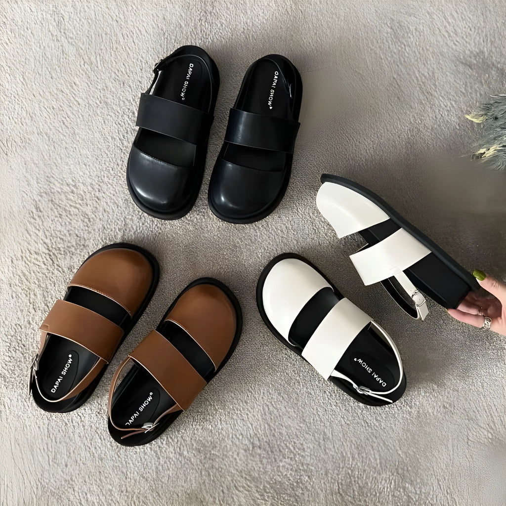 Korean style women's retro sandals with a black microfiber upper and adjustable ankle buckle on a PVC sole.