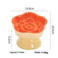 White high-foot ceramic pet bowl with slanted rim on a wooden floor, suitable for dogs and cats.