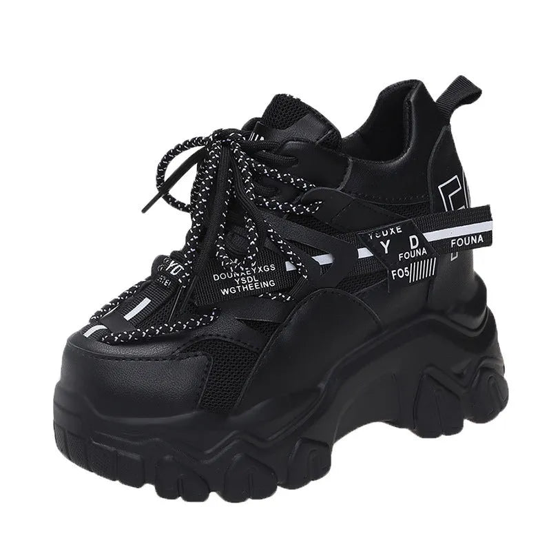 Women's white and black platform sports shoes with cross strap and rubber sole.