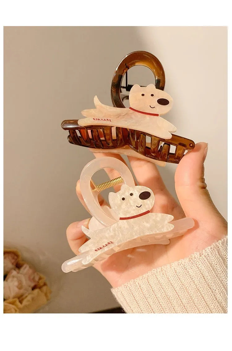 Beige and brown cartoon puppy-shaped hair grip barrettes on a white background.