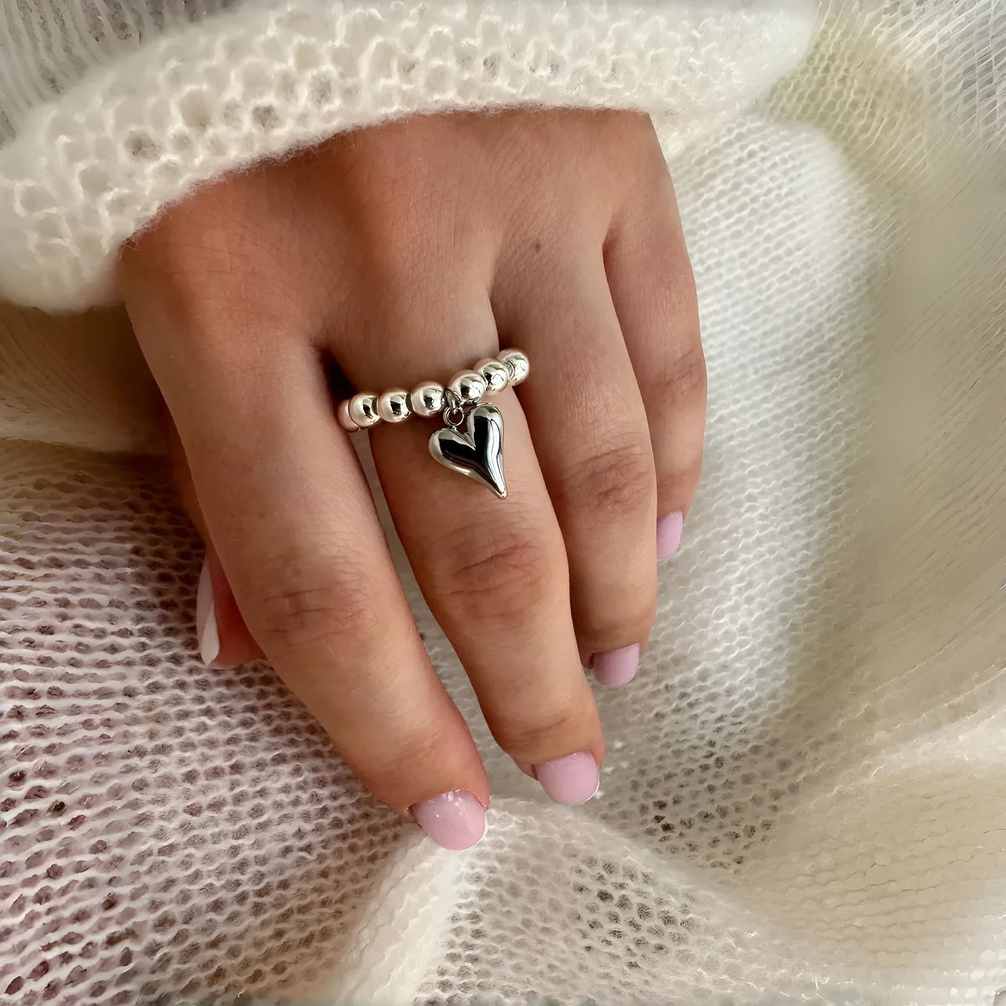 Handmade gold and white elastic beaded ring with a geometric love heart design.