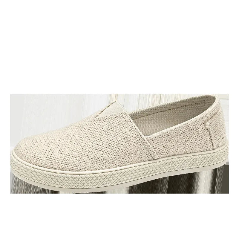 Men's beige linen canvas slip-on shoes with round toe and shallow cut design on a grey background.