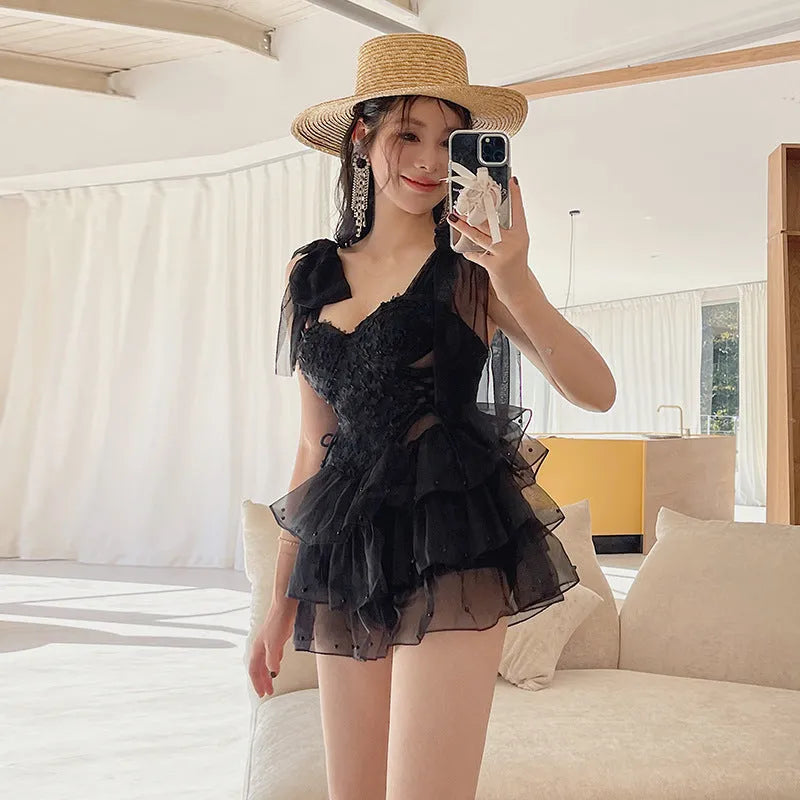 Black sleeveless one-piece swimsuit with a gathered bust and conservative fit.