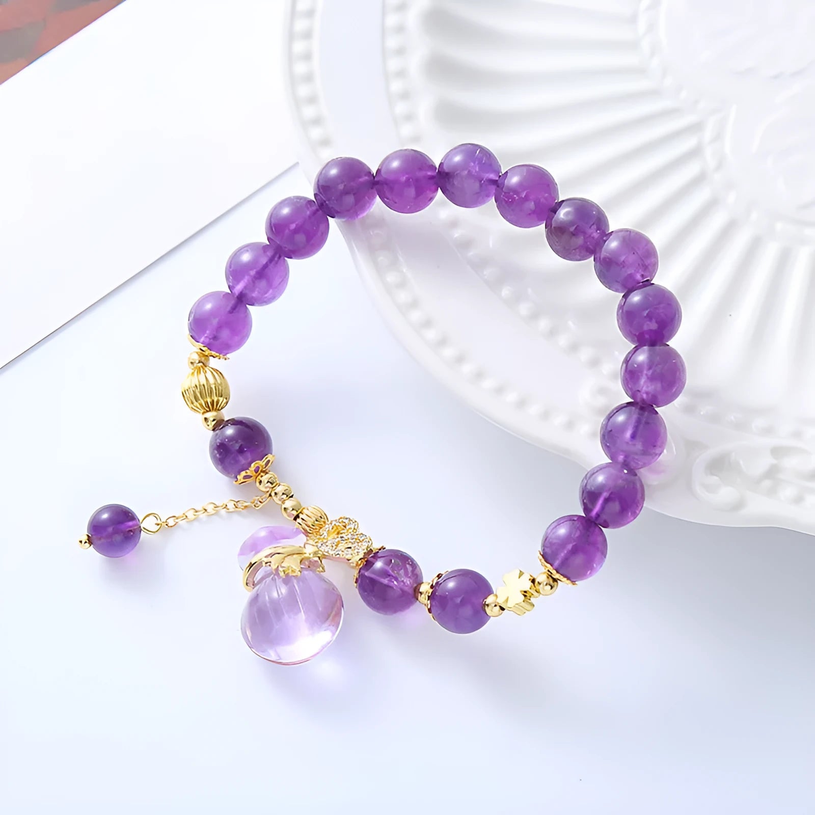 Purple amethyst crystal bracelet with money bag charm and peace buckle on woman's wrist