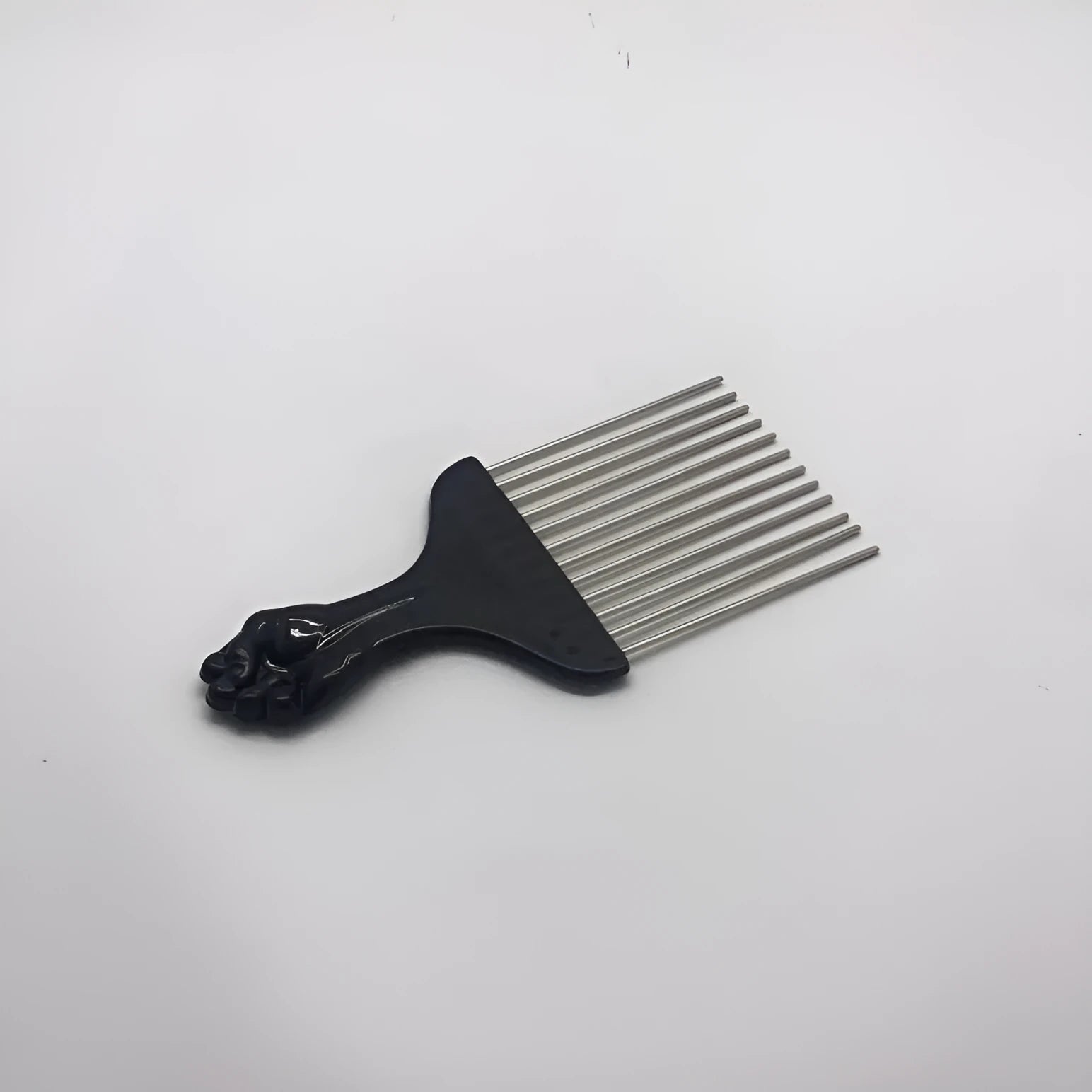 Male creative portable steel needle comb in plastic, over 20cm long, with steel teeth on a light background.