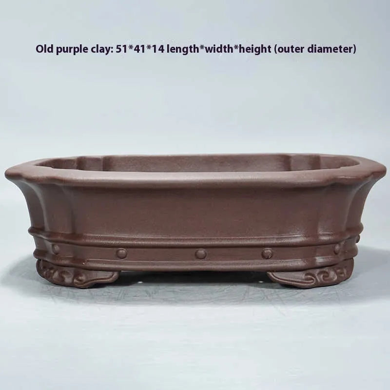 Purple sand clay handmade rectangular antique begonia flower pot on a desktop.