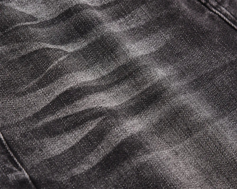 Men's black washed denim jeans on a flat surface showing full leg and pocket details